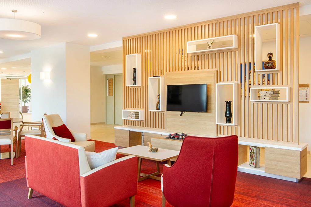 Espace confort d'un établissement médicalisé avec meuble sur mesure en bois par un architecte décoration d'intérieur